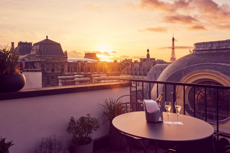 Un cafe parisien typique avec des tables en terrasse et la tour eiffel en arriere-plan